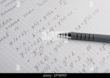 Papier avec calculs mathématiques écrits et stylo, gros plan Banque D'Images