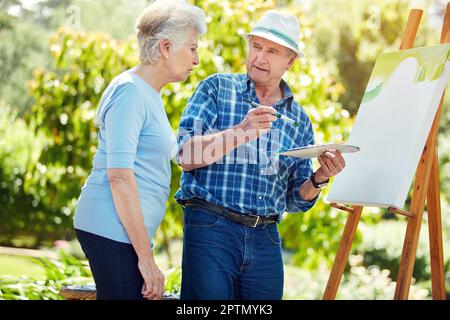 Qu'aimeriez-vous que je peint ? un couple senior peint dans le parc. Banque D'Images