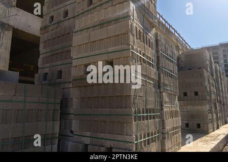 Gros plan d'un grand nombre de blocs de béton, de briques grises homogènes, de matériaux de construction sur un chantier de construction. Banque D'Images