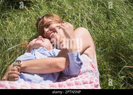 Femme avec son fils couché sur l'herbe et pique-nique, Bavière, Allemagne Banque D'Images