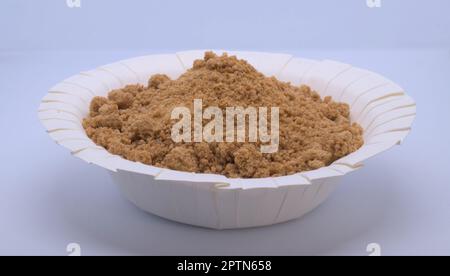 Poudre de jaggery biologique sur fond blanc. Banque D'Images