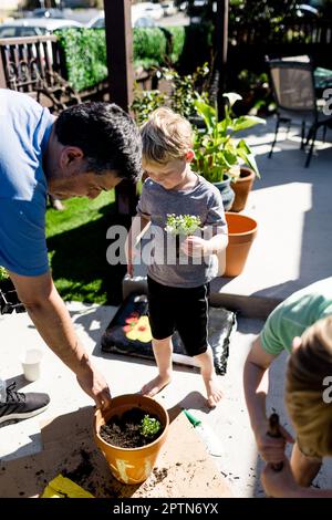 Neveux plantant des fleurs avec Oncle pour le printemps à San Diego Banque D'Images