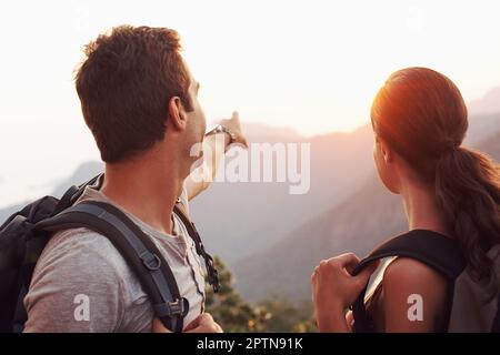 On s'y dirigea vers ce point... Un jeune homme qui pointe vers l'horizon tandis que sa petite amie regarde Banque D'Images