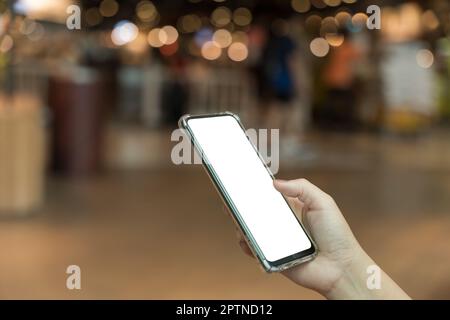Smartphone à main femelle avec écran vierge sur fond bokeh clair Banque D'Images