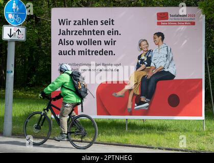 Une grande affiche appelant aux élections sociales de 2023 sur 31 mai 2023 se trouve dans une rue très fréquentée, un cycliste conduit devant elle. Elle a lieu tous les six ans pour tous les prestataires d'assurance-retraite, d'assurance-maladie et d'assurance-accident. Oberhausen, 27 avril 2023 Banque D'Images