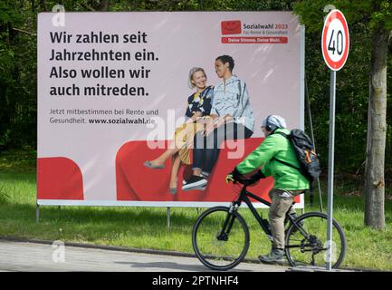 Une grande affiche appelant aux élections sociales de 2023 sur 31 mai 2023 se trouve dans une rue très fréquentée, un cycliste conduit devant elle. Elle a lieu tous les six ans pour tous les prestataires d'assurance-retraite, d'assurance-maladie et d'assurance-accident. Oberhausen, 27 avril 2023 Banque D'Images