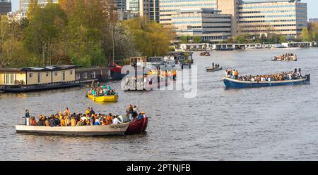 Amsterdam, pays-Bas, 27.04.2023, bateaux de fête sur la rivière Amstel avec des personnes célébrant la Journée du Roi (Koningsdag en néerlandais) Banque D'Images