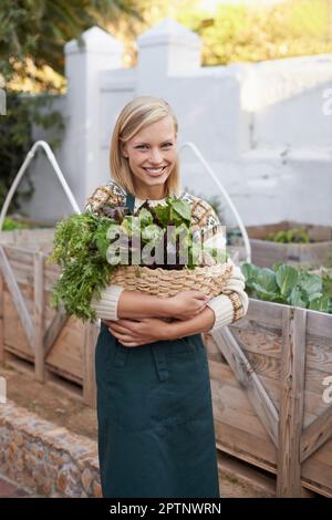 Je ne choisis que les plus frais. Portrait d'une jeune femme attrayante faisant du jardinage de légumes Banque D'Images