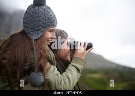 En prenant la vue comme la randonnée jusqu'au sommet. Un jeune couple prend dans tous les paysages tout en appréciant une randonnée en montagne Banque D'Images