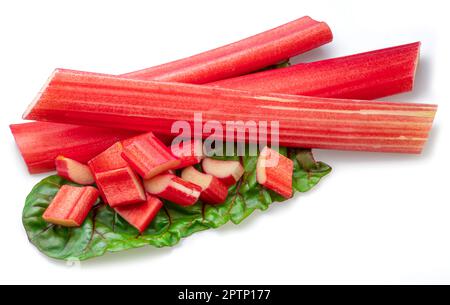 Les tiges de rhubarbe rouges se découpent sur les feuilles de rhubarbe isolées sur fond blanc. Banque D'Images