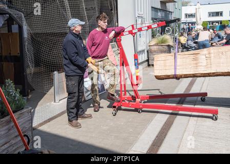 Le déchargement des grumes à l'aide d'une grue d'atelier hydraulique de 2000k se tient au Longshed dans Woodbridge Suffolk où un bateau de réplique est en cours de construction. Banque D'Images