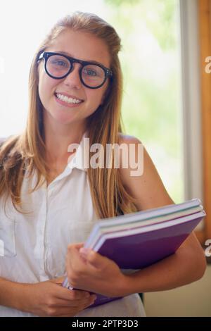 Étudier n'est jamais une corvée pour moi. une jeune fille dans le couloir de son école Banque D'Images