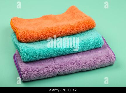 Pile de nouveaux vêtements et balais en microfibre doux et colorés pour le ménage, la vue en grand angle et les gros plans Banque D'Images
