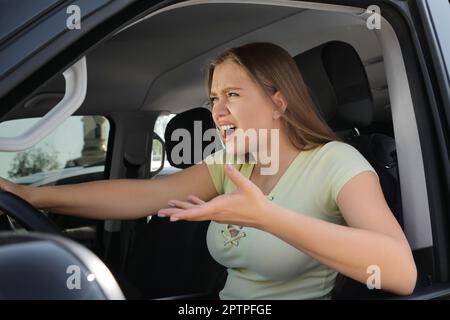 Femme émotive en voiture. Comportement de conduite agressif Banque D'Images