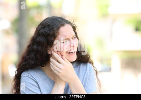 Femme souffrant de douleur à la mâchoire dans la rue Banque D'Images