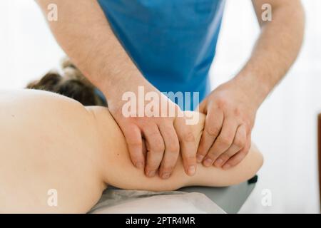 Une jeune femme de gras reçoit un massage dans un cabinet de spa de jour. Banque D'Images