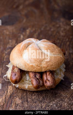 Saucisses de Nuremberg avec choucroute dans un petit pain Banque D'Images