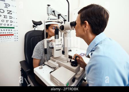 Examen, examen ou dépistage des yeux et de la vision avec un optométriste, un opticien ou un ophtalmologiste et un patient utilisant un ophtalmoscope. Test et vérification Banque D'Images