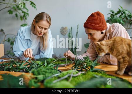 Joyeux couple de famille décorateur travaillant sur la composition florale dans le studio d'art d'atelier confortable Banque D'Images