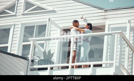 Amoureux jeune couple de course mixte en pyjama partageant un moment romantique tout en dansant sur le balcon de leur nouvelle maison ou pendant les vacances appréciant leur ho Banque D'Images