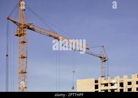 Hauteur de travail à l'intérieur de place pour grues avec de grands bâtiments en construction contre un ciel bleu clair. Grue et l'établissement de cours avec copyspa Banque D'Images