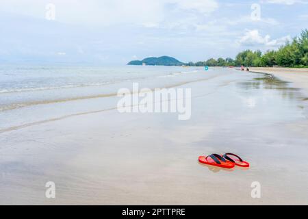 Chaussures rouges sur la plage à la lumière du jour Banque D'Images