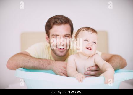 HES toujours là pour s'occuper d'elle. Un jeune père se liant à sa fille au moment du bain Banque D'Images