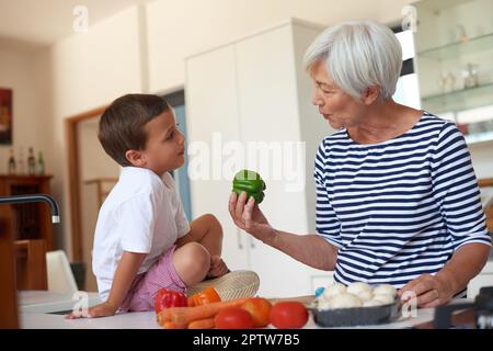 Frais du jardin de grands-Noël. une grand-mère préparant le dîner avec son petit-enfant dans une cuisine Banque D'Images