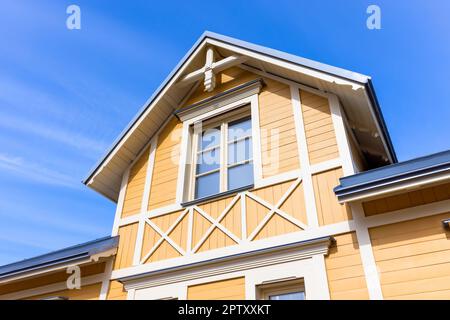 Nouvelle maison de campagne en bois fragment extérieur, pignon jaune avec décor blanc Banque D'Images