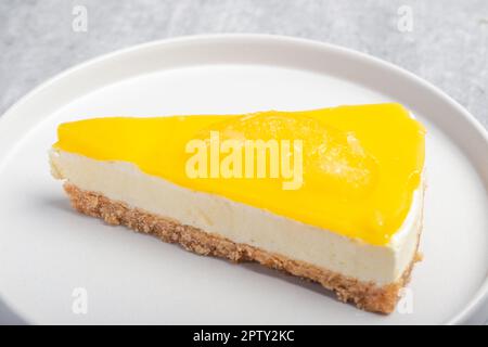 Cheesecake triangulaire au citron sur une assiette blanche Banque D'Images