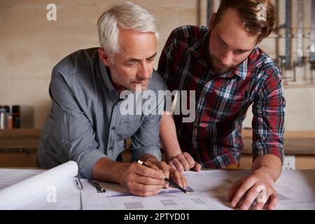 C'est ce qu'ils font le mieux. deux architectes établissant des plans de construction Banque D'Images