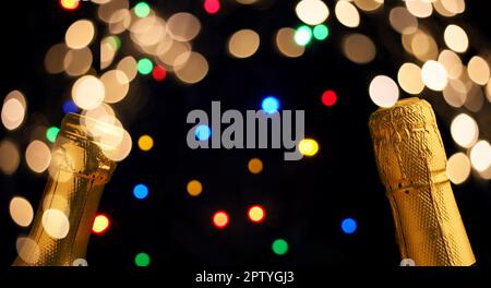 Deux bouteilles de champagne sur fond bokeh coloré avec lumières de Noël, concept nouvel an Banque D'Images