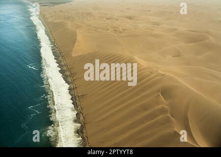 Photographie aérienne de vol au-dessus des dunes qui rencontrent l'océan Atlantique Namibie Banque D'Images