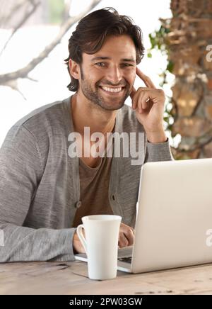 HES toujours en ligne première chose le matin. un jeune homme travaillant sur un ordinateur portable à la maison Banque D'Images