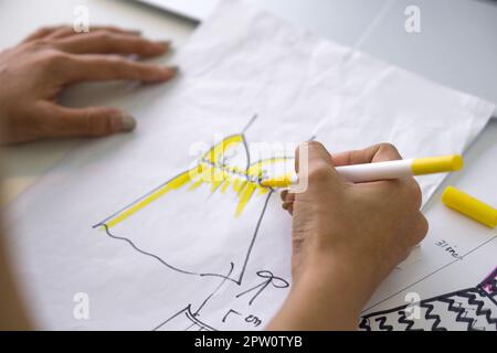 Gros plan mode designer main utiliser Magic stylo peinture sur le motif pour le tissu. Banque D'Images
