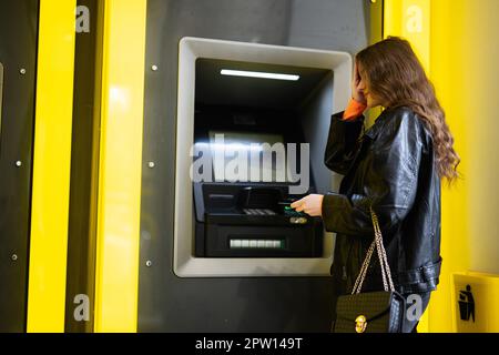 Oh non, j'ai oublié le code PIN. Jeune fille brunette déçue de retirer de l'argent de la carte de crédit à jaune ATM. Banque D'Images