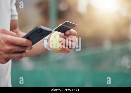 Gros plan d'un joueur inconnu de tennis de course mixte utilisant un téléphone portable et une carte de crédit sur le court. Athlète hispanique de la forme payant pour l'adhésion au sport sur un téléphone dans Banque D'Images