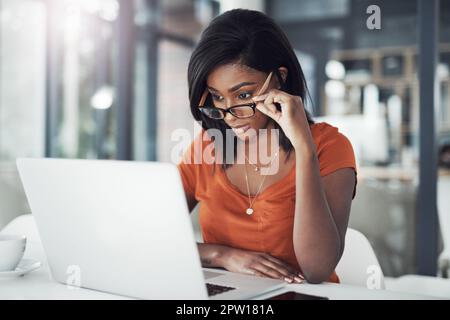 En regardant de plus près les choses. une jeune femme d'affaires attirante travaillant sur un ordinateur portable à son bureau Banque D'Images