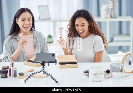 Happy influenceur faisant le podcast vidéo de révision de maquillage pour le blog de beauté en ligne ou vlog en utilisant son téléphone à la maison. Créateur de contenu féminin ou influenceur en direct Banque D'Images