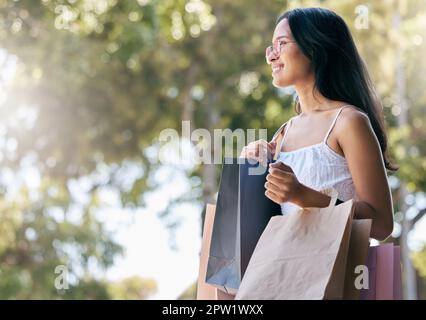 Mode, vente au détail et femme avec des sacs de shopping en ville après avoir fait du shopping dans un centre commercial, une boutique ou un magasin de vêtements. Réduction pour le Vendredi fou, bonnes affaires et heureux Banque D'Images