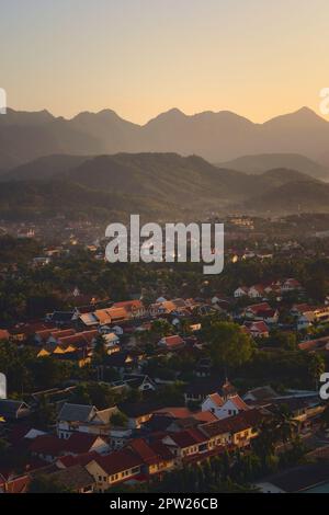 Vue élevée de la ville de Luang Prabang, Laos, au coucher du soleil, avec des montagnes sur l'arrière-plan. Banque D'Images