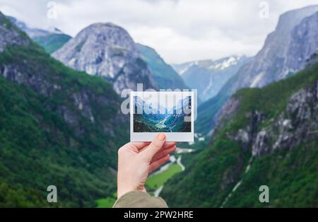 Main tenant la photo polaroid instantanée de voyage destination vallée glaciaire wanderlust concept de respiration. Banque D'Images