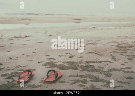 Chaussures rouges sur la plage à la lumière du jour Banque D'Images