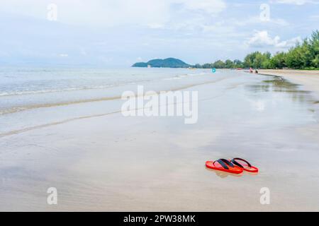 Chaussures rouges sur la plage à la lumière du jour Banque D'Images