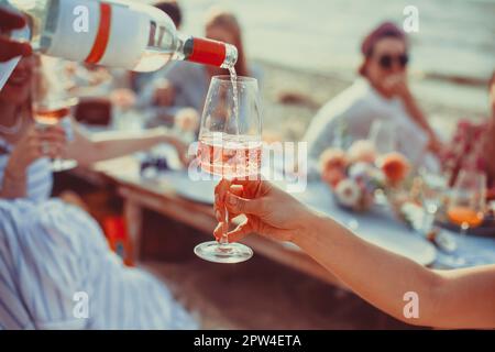 Délicieux repas et fleurs pour un pique-nique en plein air en été ou au printemps. Déjeuner sur la plage dans des couleurs romantiques Banque D'Images