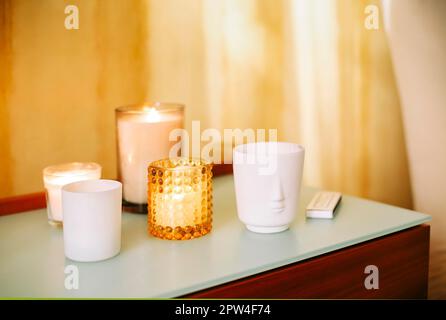 Table avec de nombreux éclairages bougies parfumées et bâtons d'encens aromatiques dans le salon de massage spa ou le studio de yoga, foyer sélectif. Lieu de méditation Banque D'Images