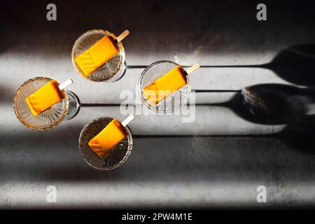 Quatre verres de champagne et de glace orange. Cocktail alcoolisé élégant sur la table lumineuse sous un doux soleil rayson. Concept de boissons délicieuses Banque D'Images