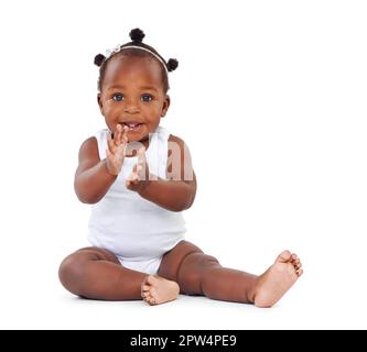 Je suis tellement enthousiaste et je ne peux pas le cacher. Photo studio d'une adorable petite fille isolée sur blanc Banque D'Images