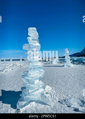 Morceaux de glace couchés sur la glace lisse idéale de baikal avec des hummocks de glace à l'horizon. Le soleil brille à travers les côtés des glaçons. Aspect floes Banque D'Images