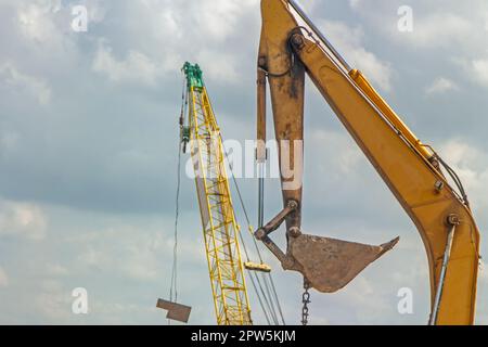 Pelle rétro jaune travaillant sur le bord de la rivière et sur le bord de la route Banque D'Images